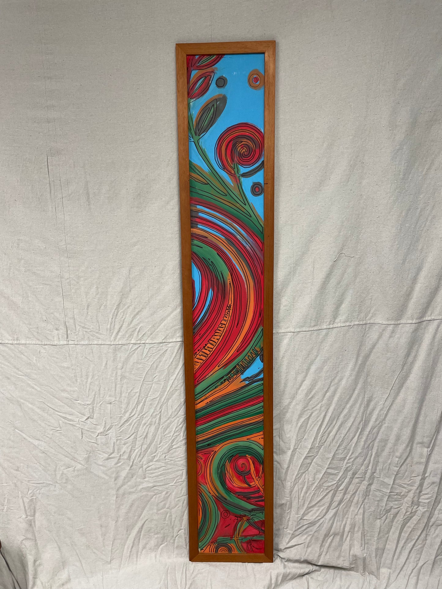 Floral Swirl original mixed media painting — tall narrow canvas with red spiral blooms and green vines on a blue background, framed in solid hardwood